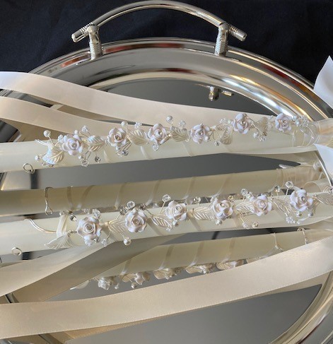 24 inch white candles with light ivory ribbon.  May also be made with white ribbon. Clay stefanotis with a bit of bling in the center.  Small leaves and rice beads cascade throughout.  

OUT OF STOCK - hope to get back in April 2022
