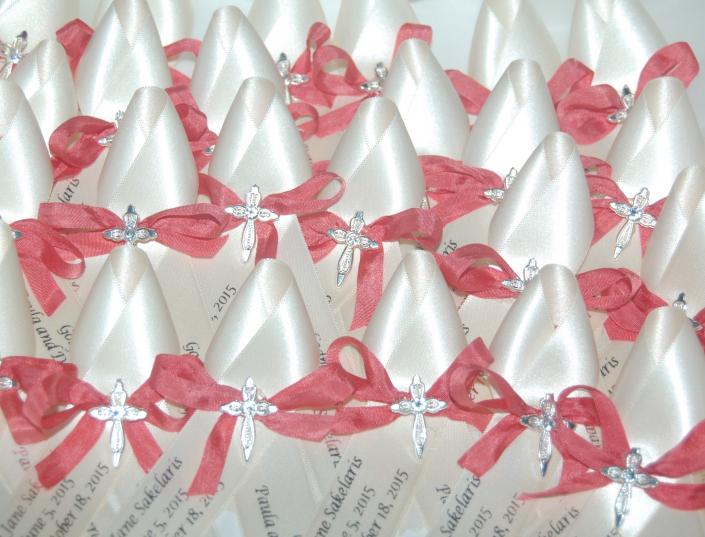 Ivory ribbon, silver lettering, coral silk bow, and silver cross with small bling.  Perfect for a fall baptism. 

Our ribbons are of the highest quality, they do not fray and the lettering is expertly done.  Please order by groups of 50 as that is how we have to order them from the printer.  