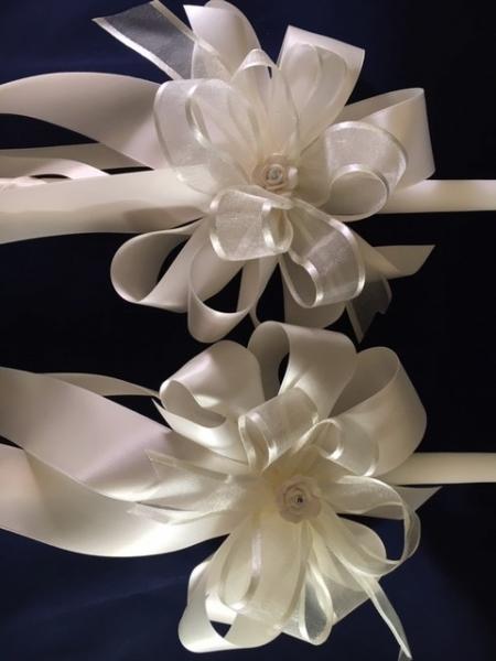 24 inch white candle set with light ivory ribbon, ceramic rose embellishment and a tough of ivory sheet ribbon to catch the church light. 

Church set of 2:  $95